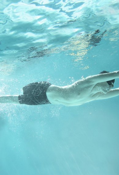 Mann im Schwimmbad unter Wasser