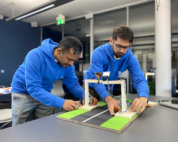 Zwei indische Studierende arbeiten gemeinsam am Ampelsystem-Modell
